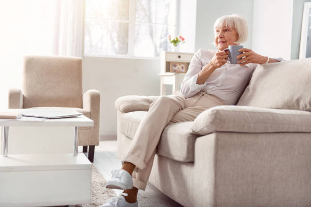 Senior woman relaxing on couch with coffee