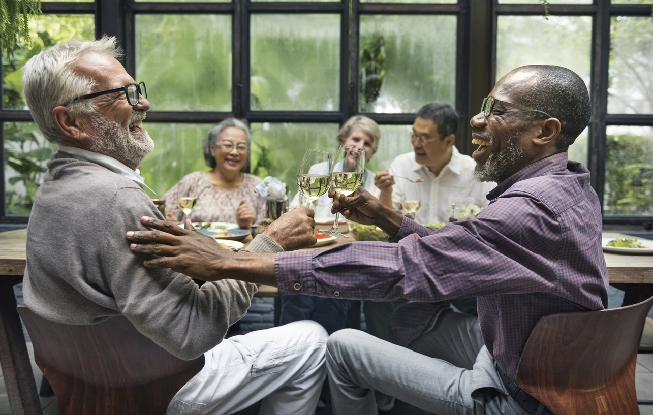 Group of friends toasting with wine at dinner party.