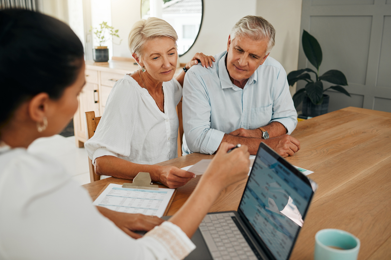 Couple consulting with financial advisor at desk.
